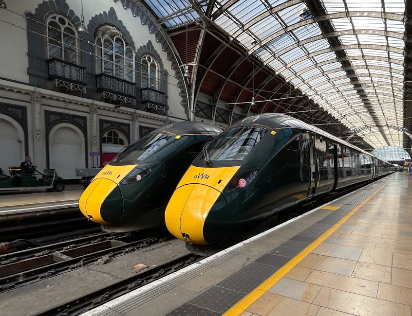 Modern high-speed trains at a historic train station under a glass roof.