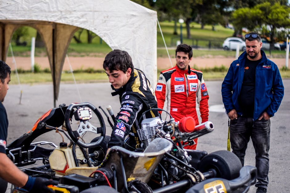 Team preparing go-kart for an outdoor race, showcasing teamwork and motorsport passion. – MIO pit guide