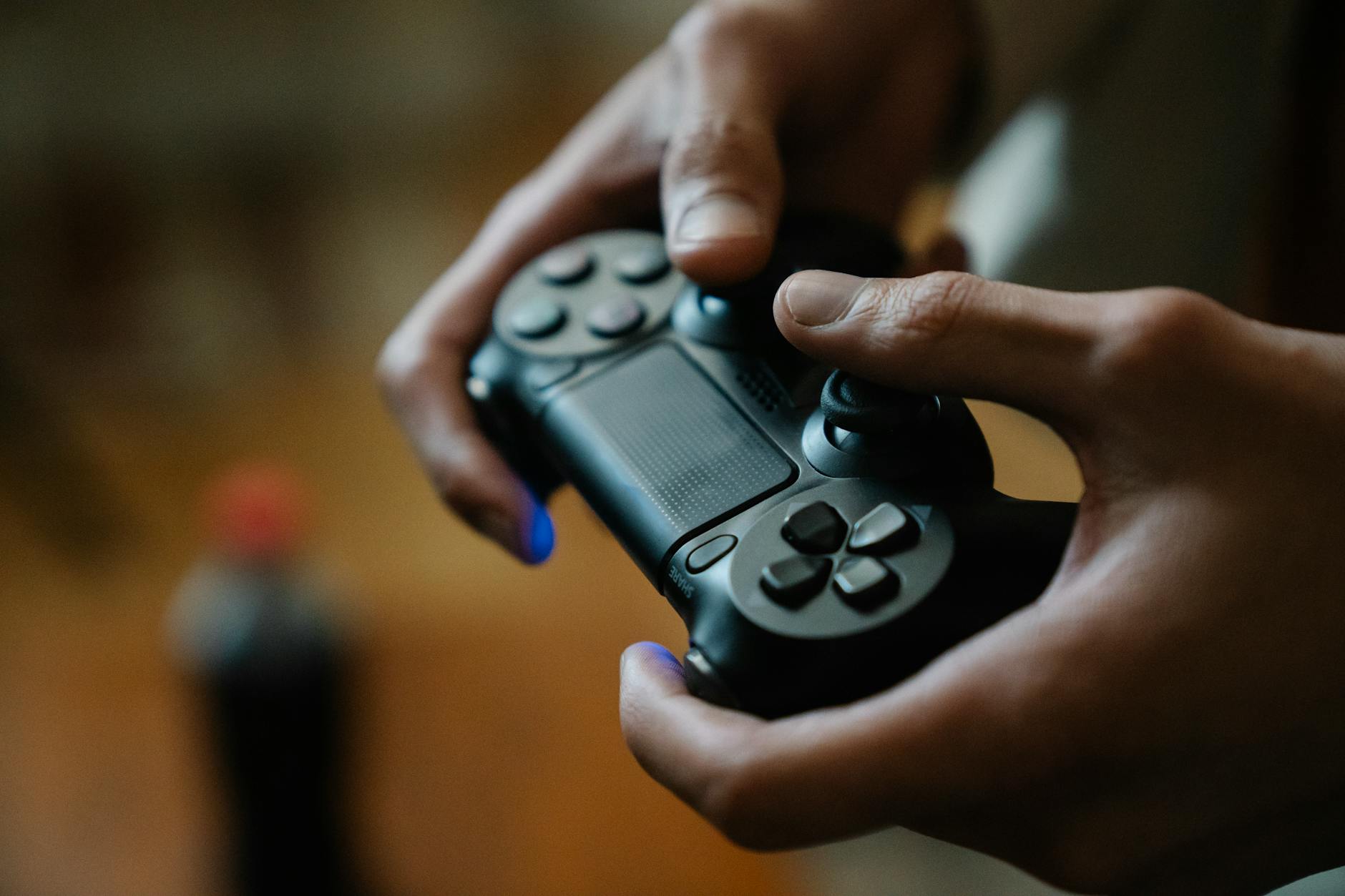 Crop anonymous male pressing buttons on console controller while playing video game in house on blurred background – Curve Games deal