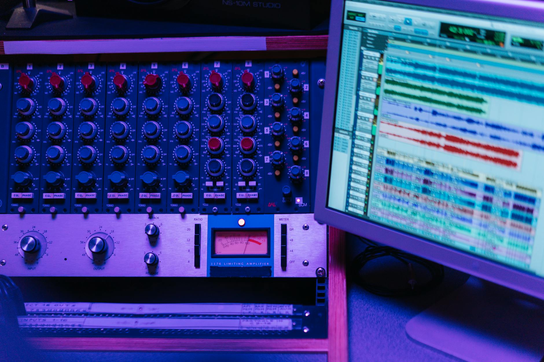 Close-up of a mixing console and screen in a recording studio, showcasing audio editing software. – Globlinz Studio 10th Anniversary Bundle