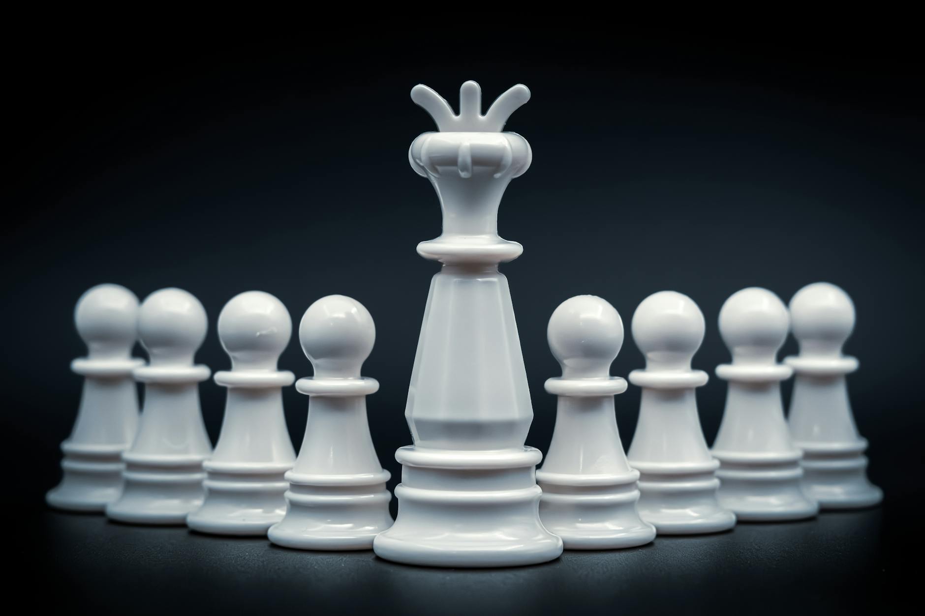 Close-up of white king and pawns on chessboard, symbolizing leadership and strategy.
