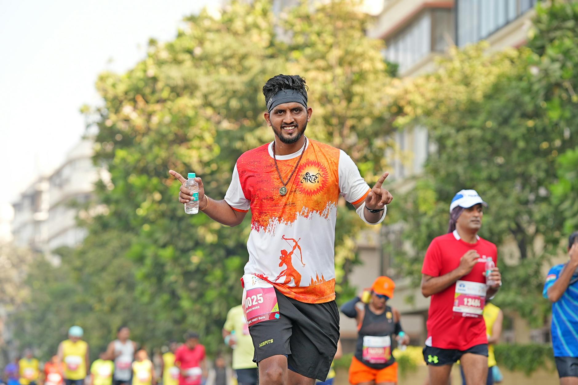 A vibrant marathon runner making a lively gesture during a race, captured outdoors.