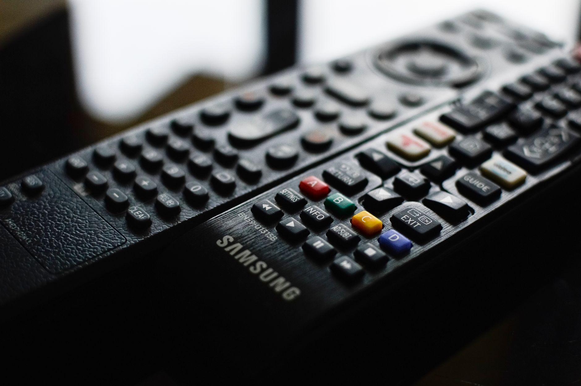 Detailed close-up of a Samsung remote control showcasing buttons and logo. – Samsung OLED reviews 2026