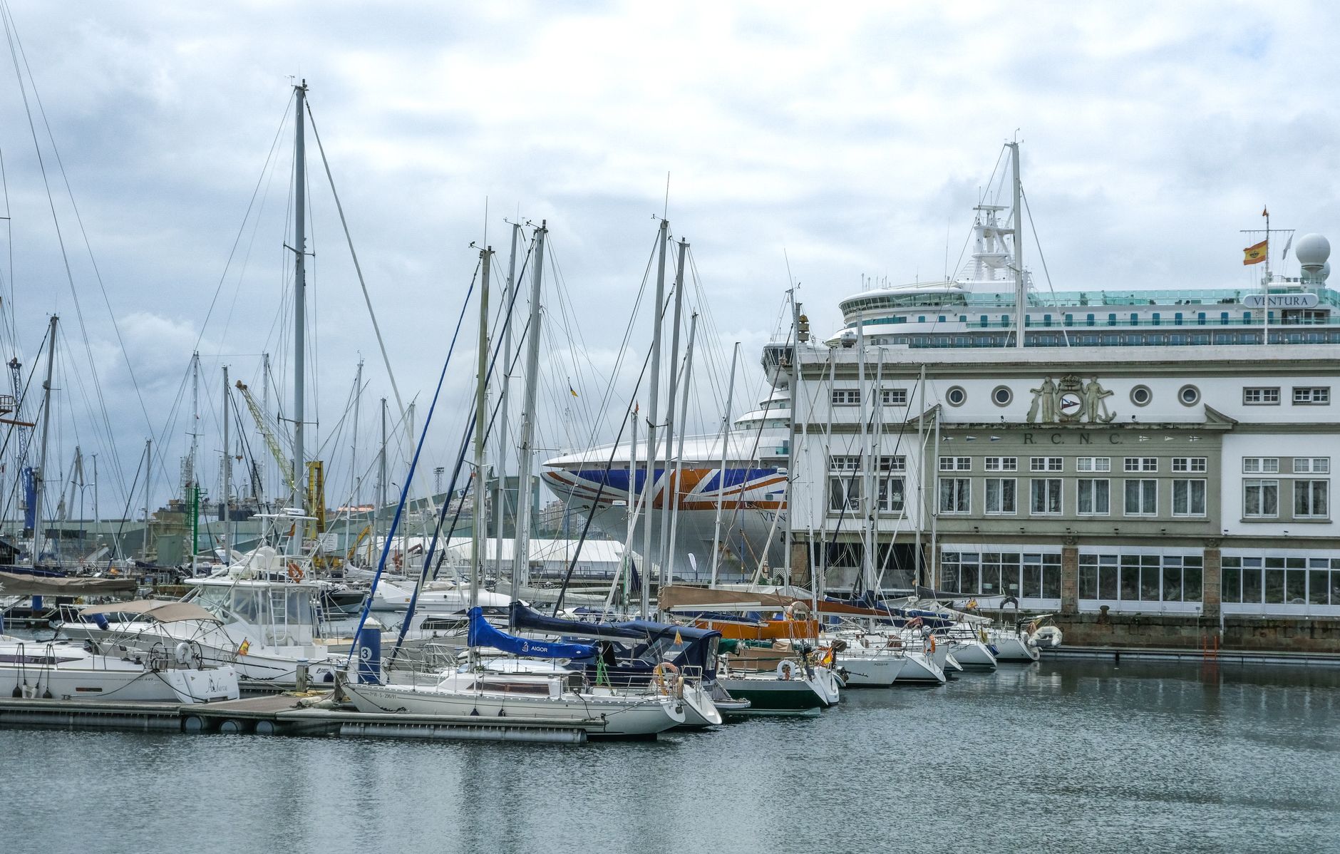 Scenic view of sailboats and cruise ship docked at the port in Corunha, Spain.
